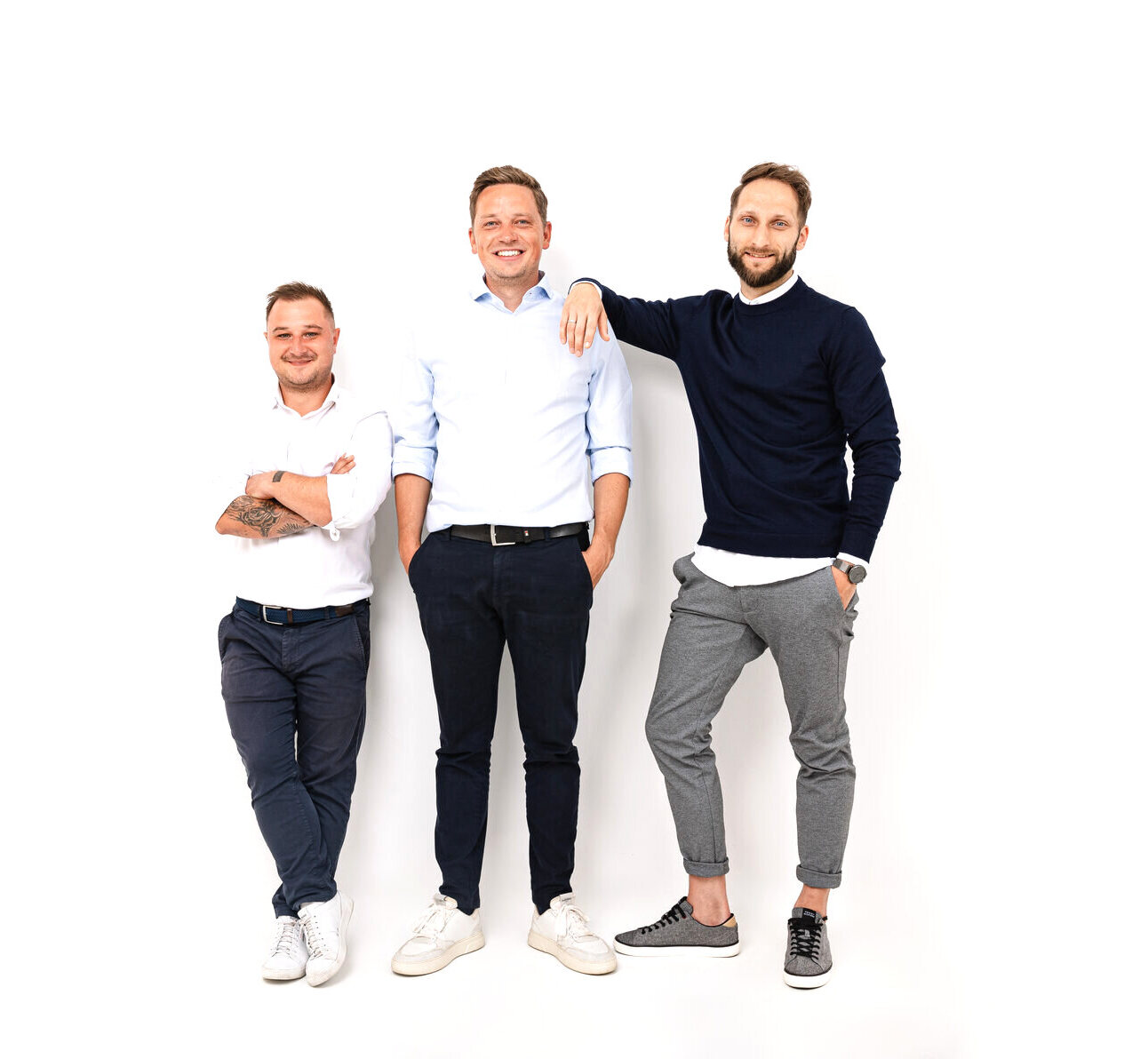 Drei FINATUR-Teammitglieder im Business-Casual-Look vor hellem Studiohintergrund