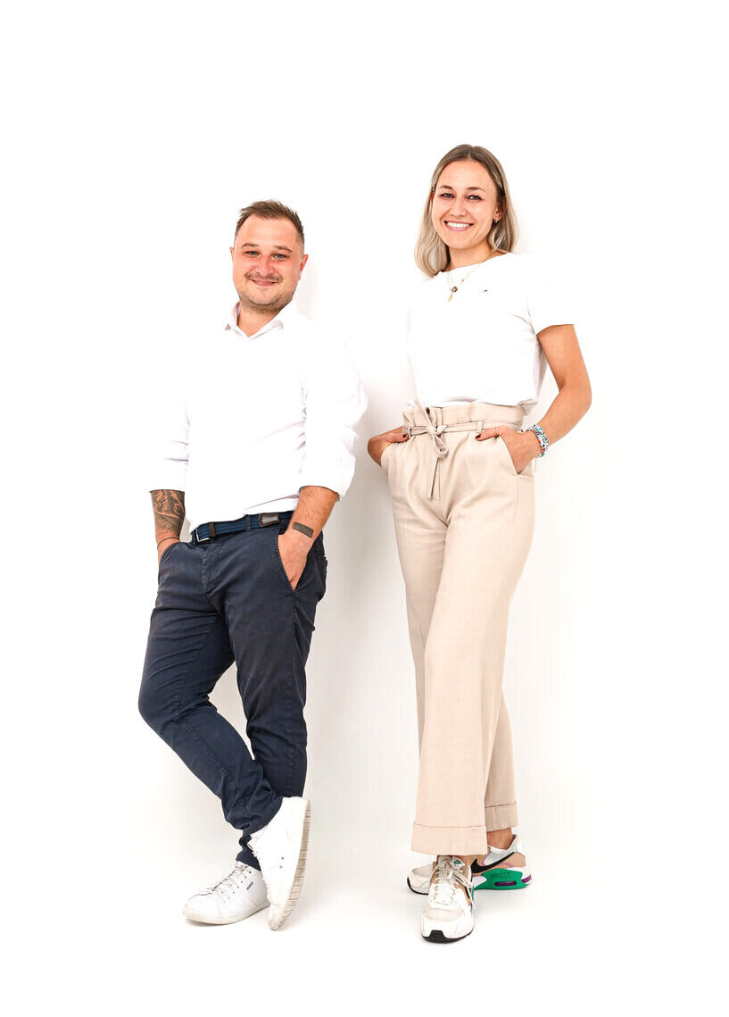 Zwei Mitglieder des FINATUR-Teams stehen freundlich vor hellem Hintergrund